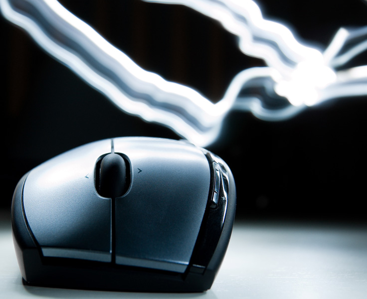 Lightpainting met behulp van een LED-knijpkat, waarvan de lichtsporen hier duidelijk aanwezig zijn. Een Logitech M610 muis vormt het onderwerp.