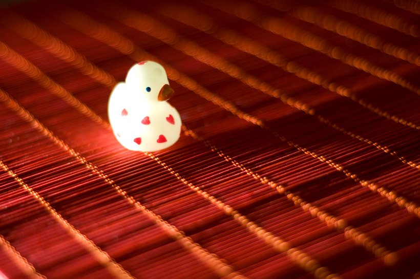 LED-knijpkat voor de belichting, rood houten matje en een fluorescerend eendje.