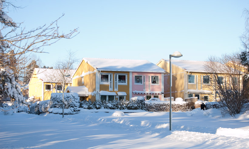 De kleur van de huizen combineert mooi met de verse sneeuw. De meeste vrijstaande huizen zijn getint zoals hier te zien of het populaire donkerrood. Overigens bestaat de wijk vooral uit hoogbouw. Er zijn bijna geen verkeer te zien, enerzijds omdat de wegen lastig begaanbaar waren en anderzijds omdat de meeste auto’s onder een laag sneeuw verstopt zitten.